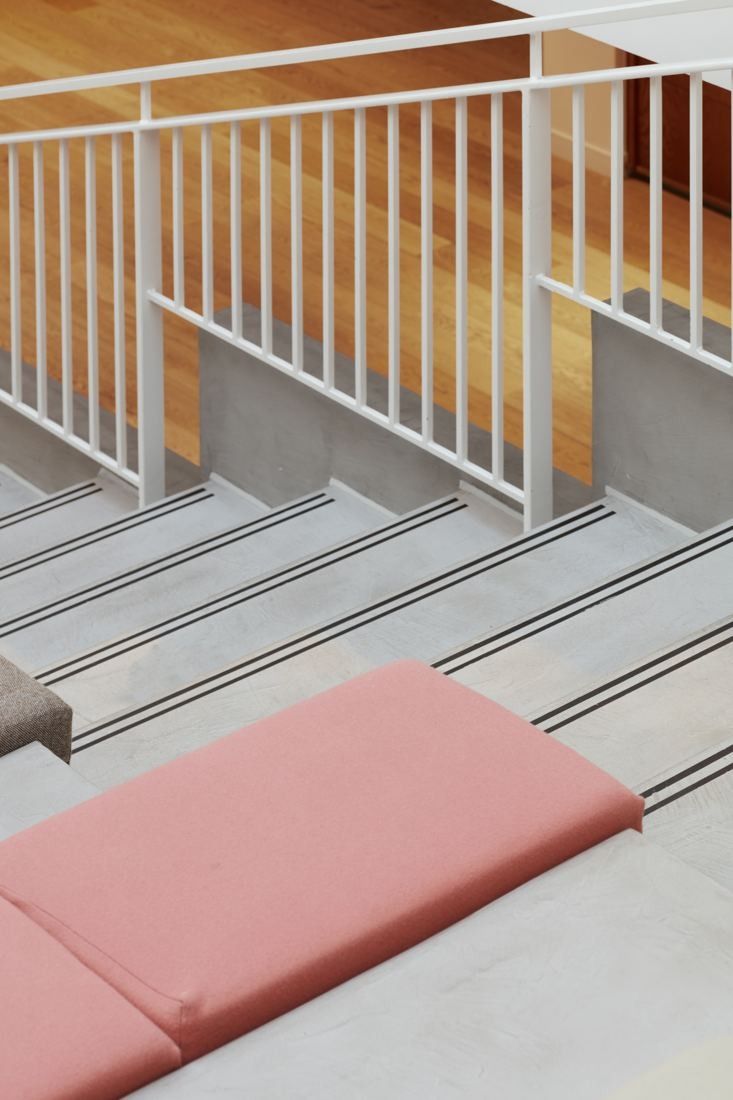 ASOS: White stair railings and stepped seating with a pink cushion