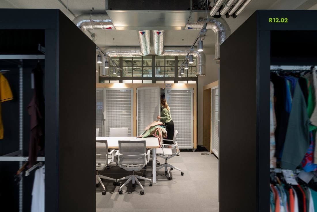 ASOS: Workroom with clothing racks, a meeting table and office chairs