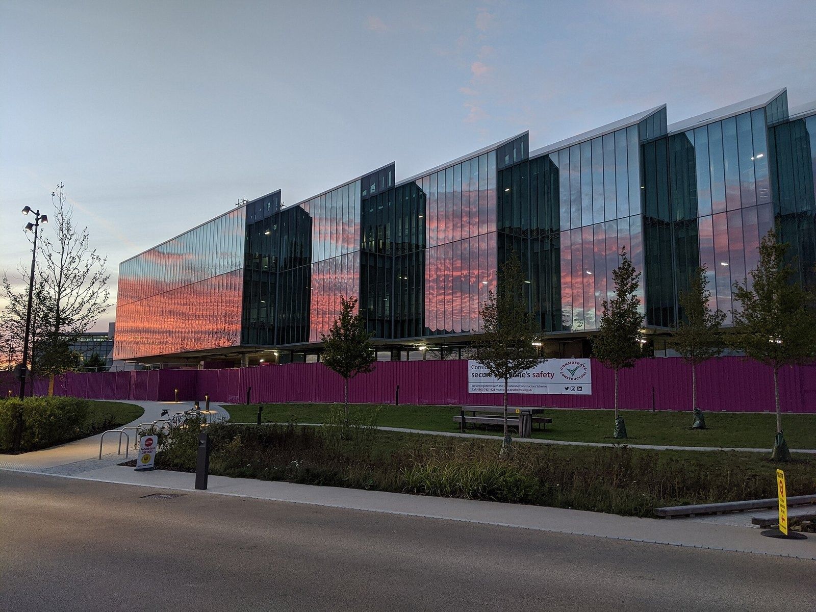 Glass building under construction at sunset