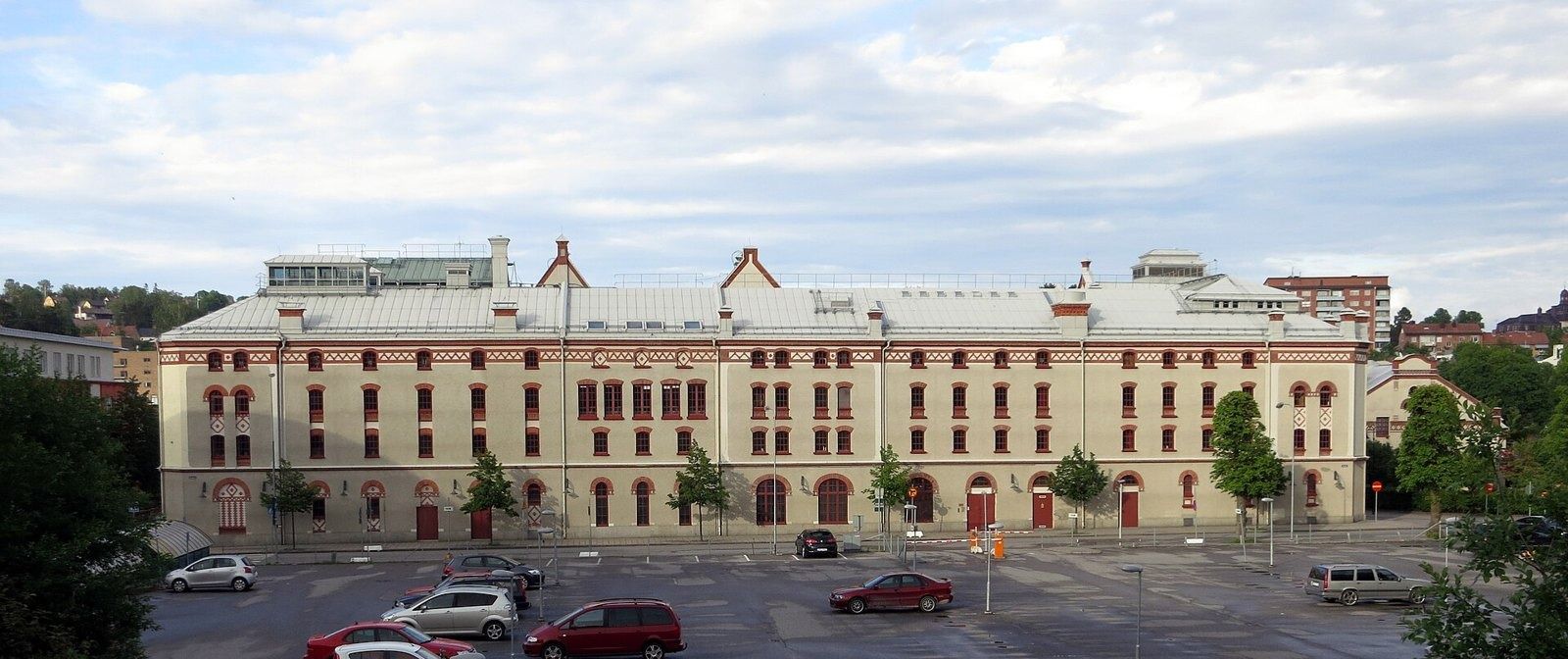 Long brick building with a car park in front
