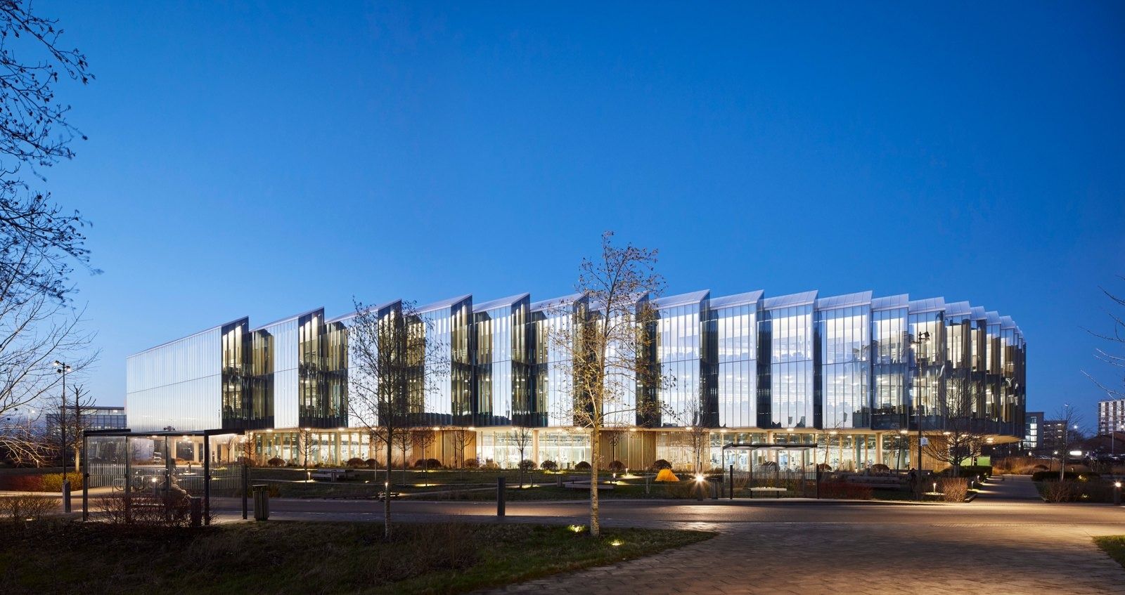 AstraZeneca: Low ring-shaped building lit at dusk
