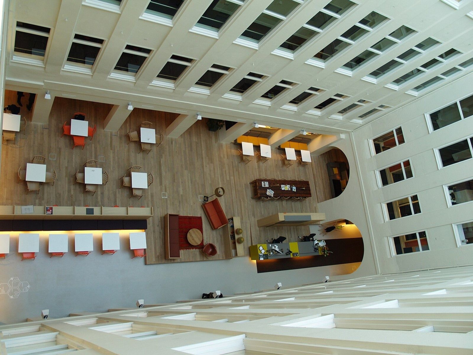 Atlassian: Looking down into a skylit atrium with red chairs and tables