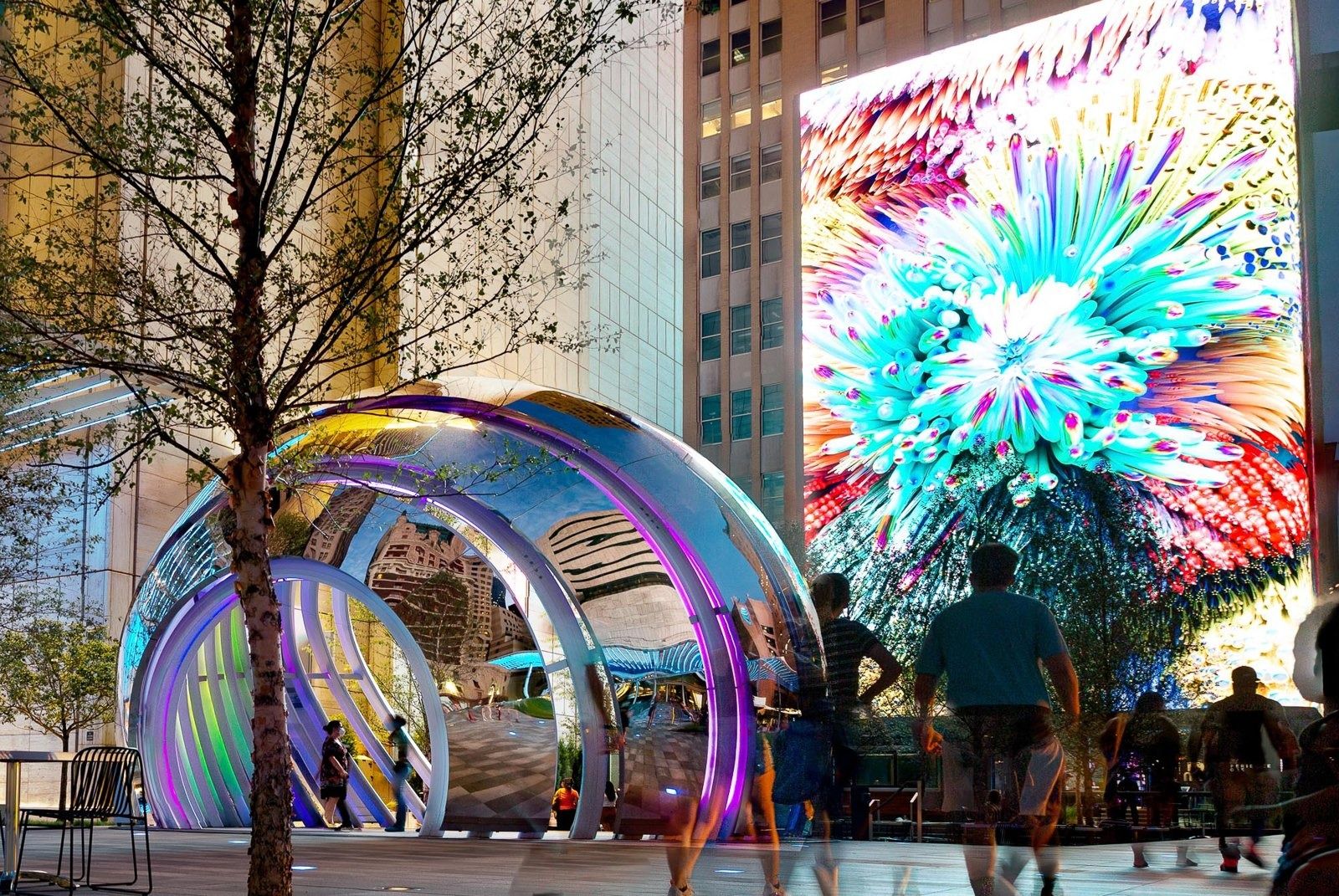 AT&T: Glowing sculpture under trees beside a video wall