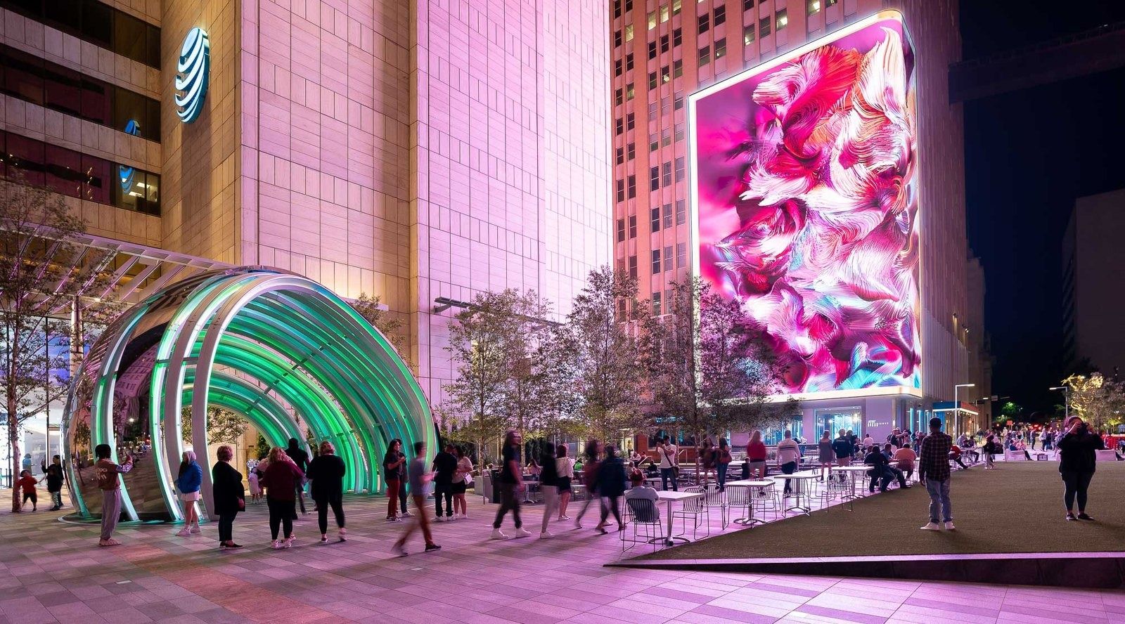 AT&T: Rainbow tunnel sculpture beside a tower with a video wall