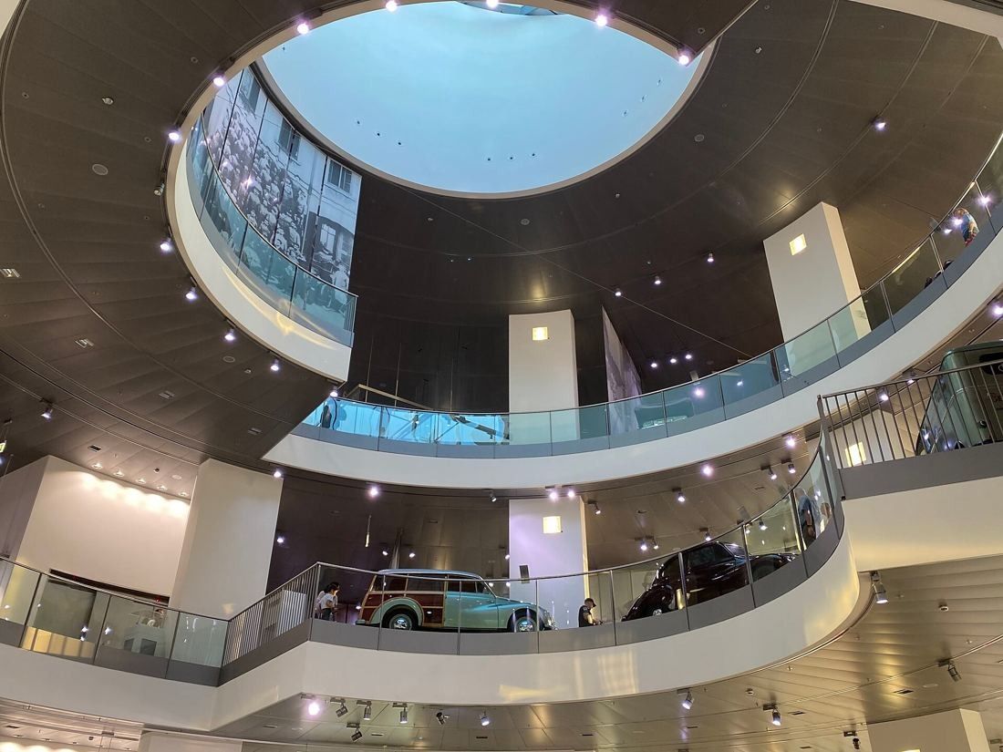 Audi: Interior atrium with curved balconies around a circular opening, cars displayed on each level