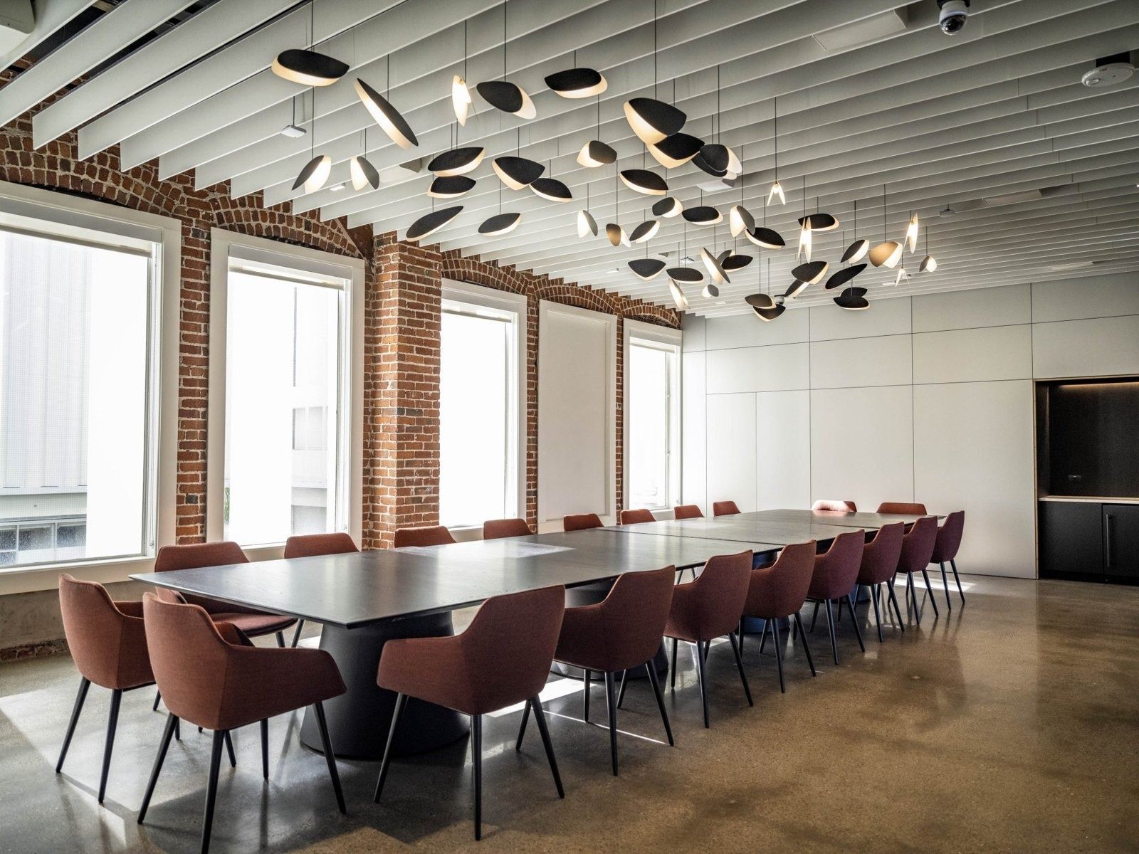 Autodesk: A long boardroom table under a cluster of disc lights