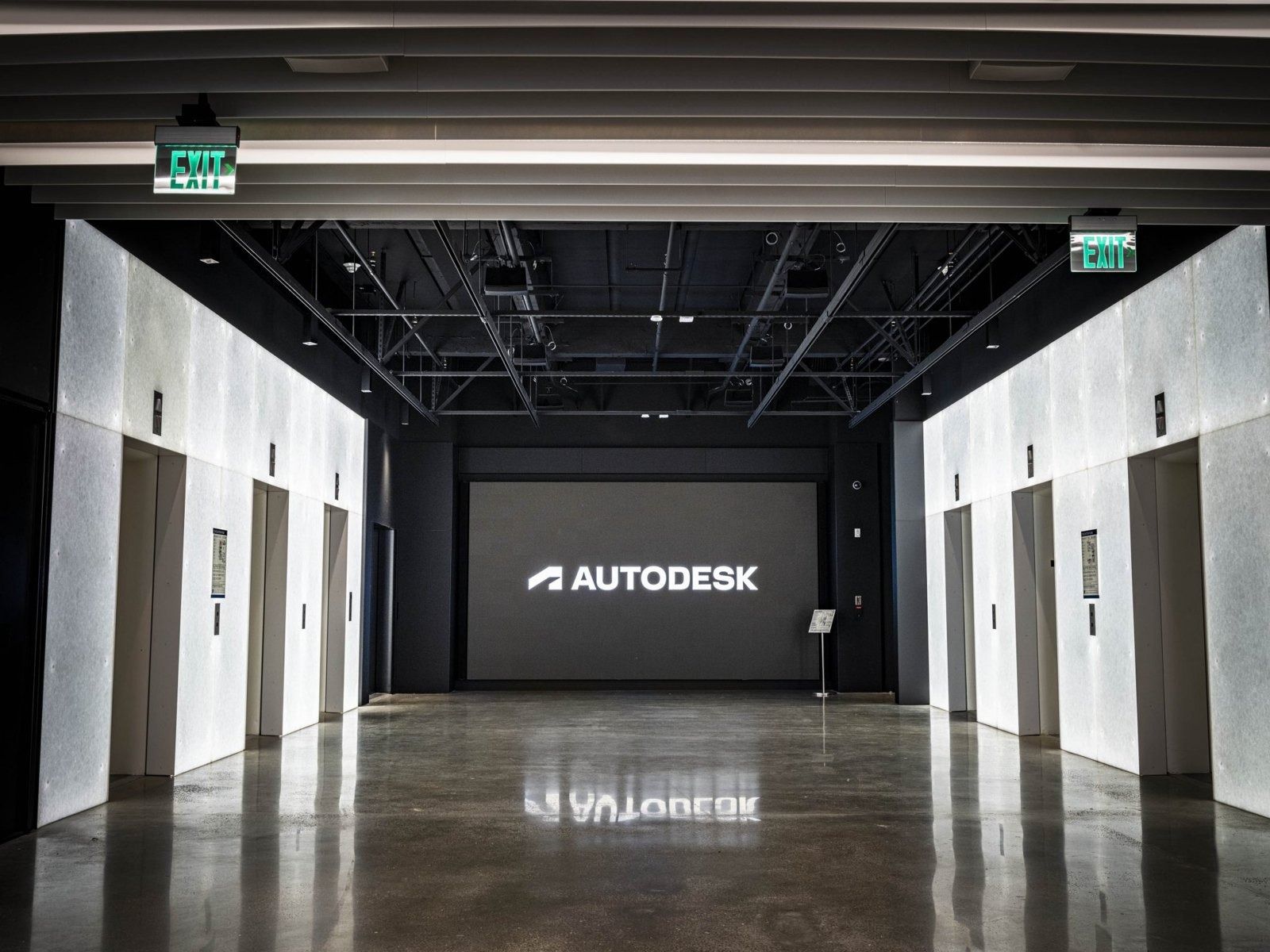 Autodesk: An event room with the Autodesk logo on a screen