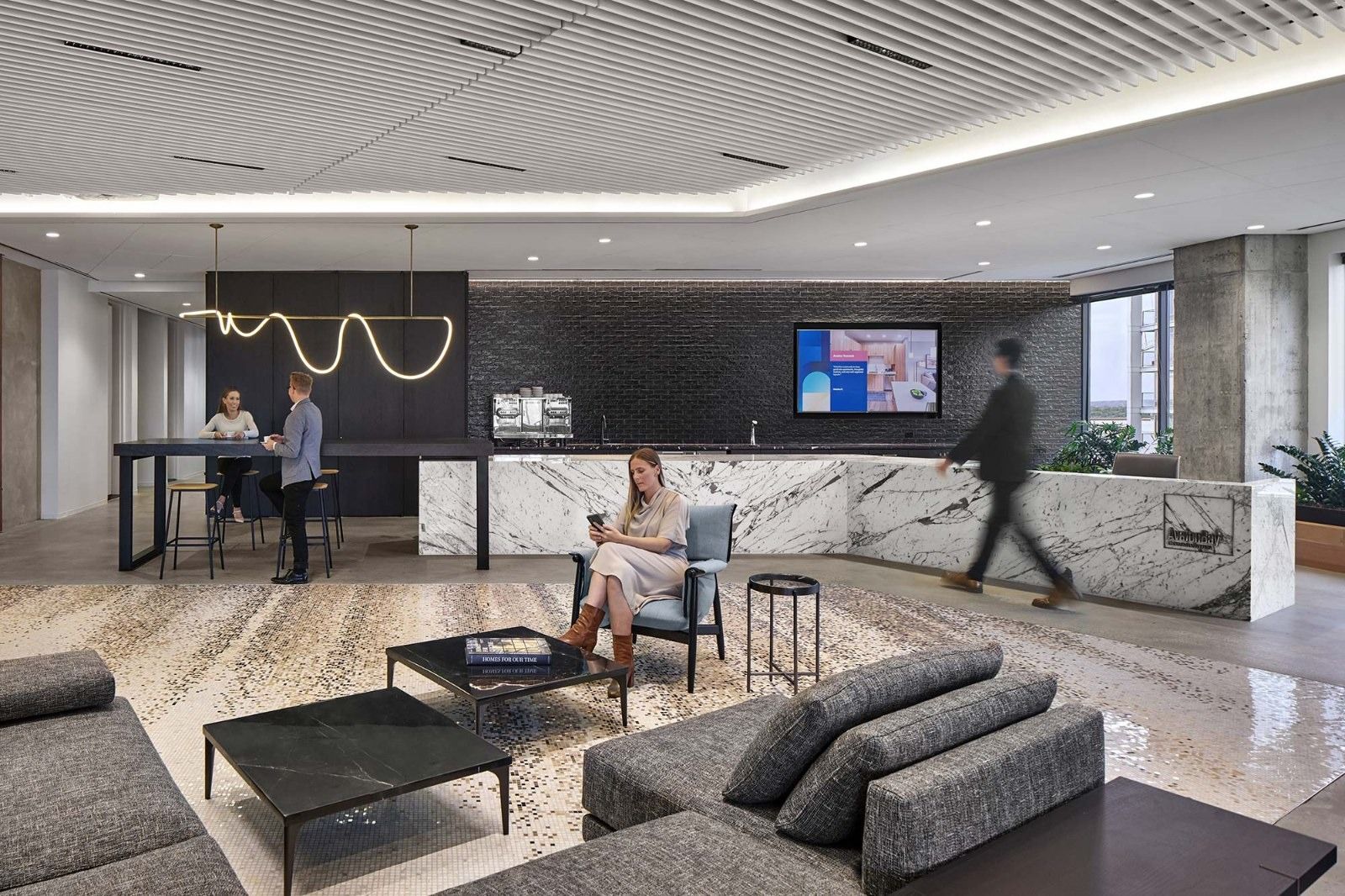 AvalonBay Communities: A lounge with grey sofas and a marble kitchen counter with a wavy neon light