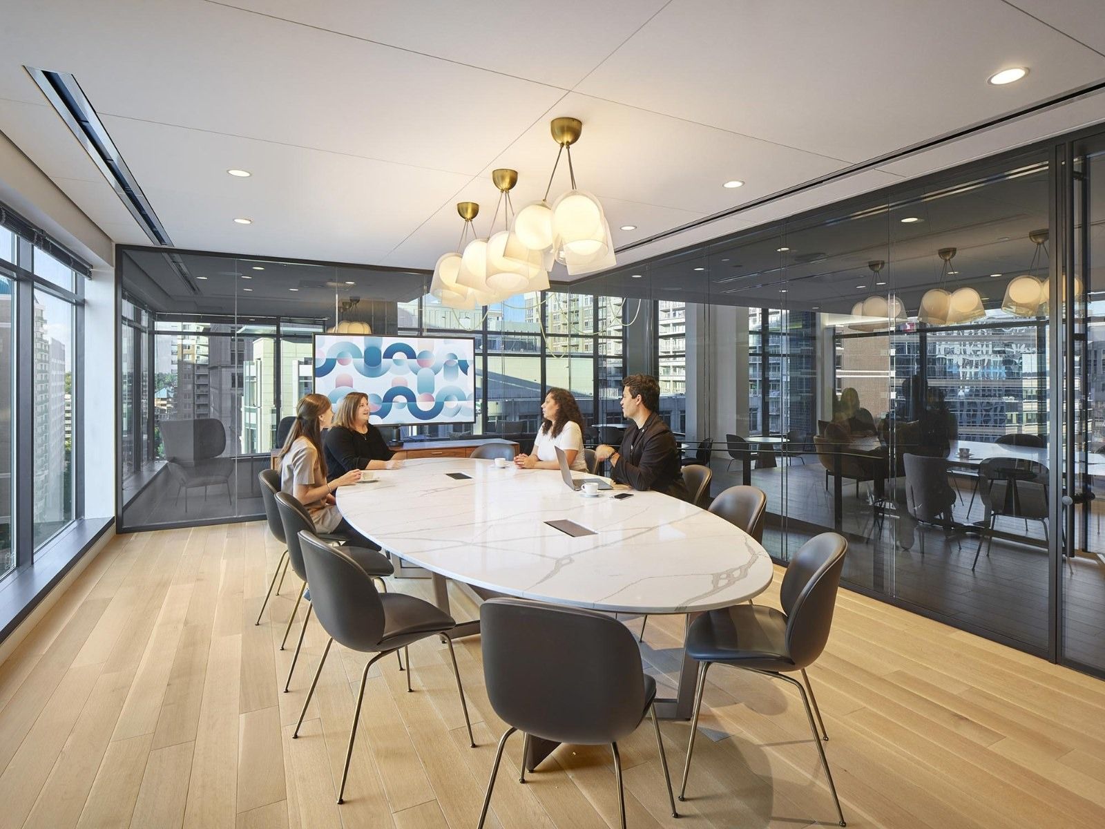 AvalonBay Communities: A round white table with gray chairs under a cluster of glass globe lights