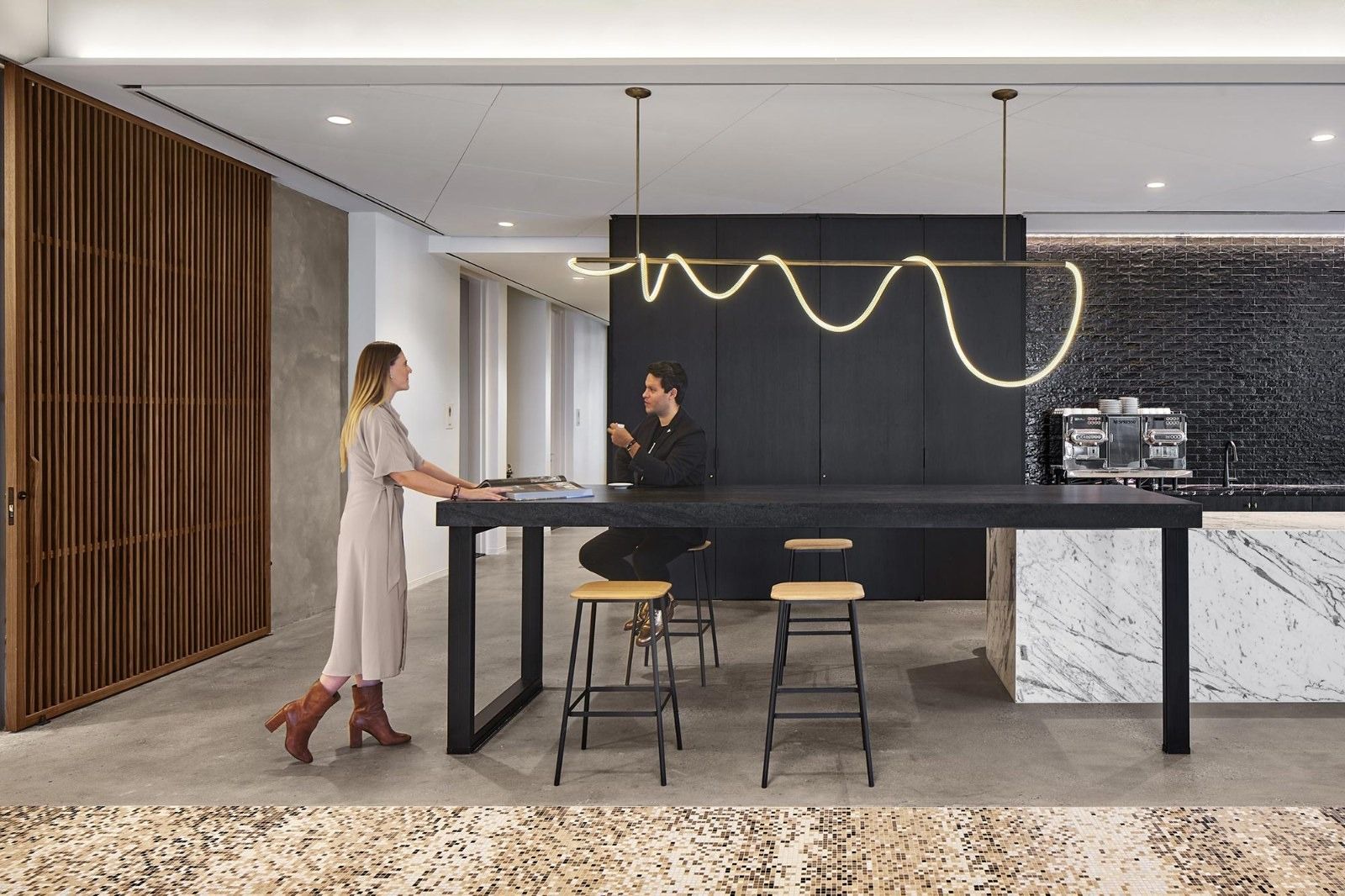 AvalonBay Communities: A tall black counter with stools and a wavy neon light