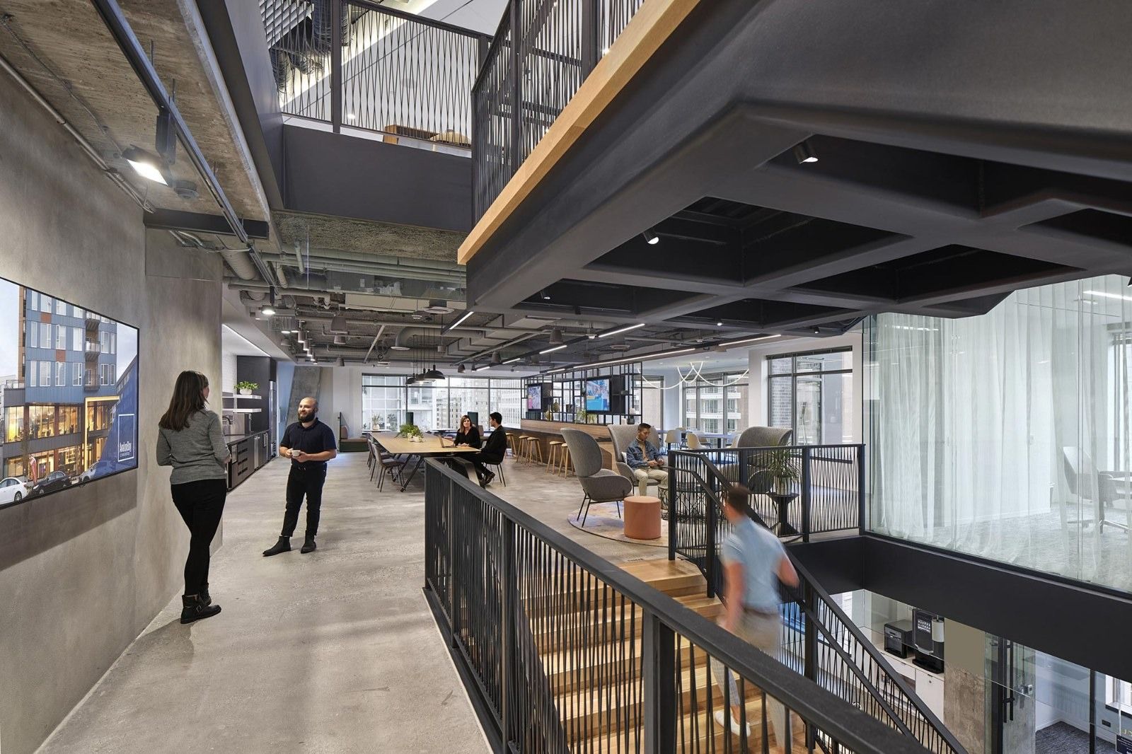 AvalonBay Communities: A walkway along an opening between floors with a black railing