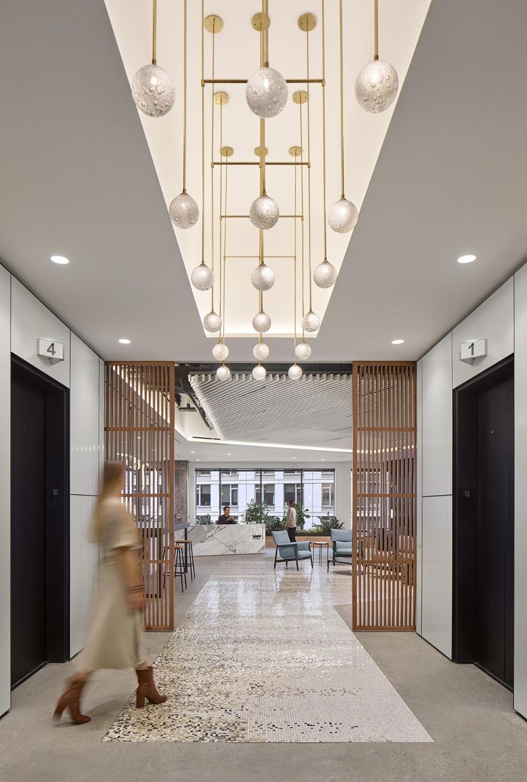 AvalonBay Communities: An elevator lobby with a sculptural chandelier and a woven carpet