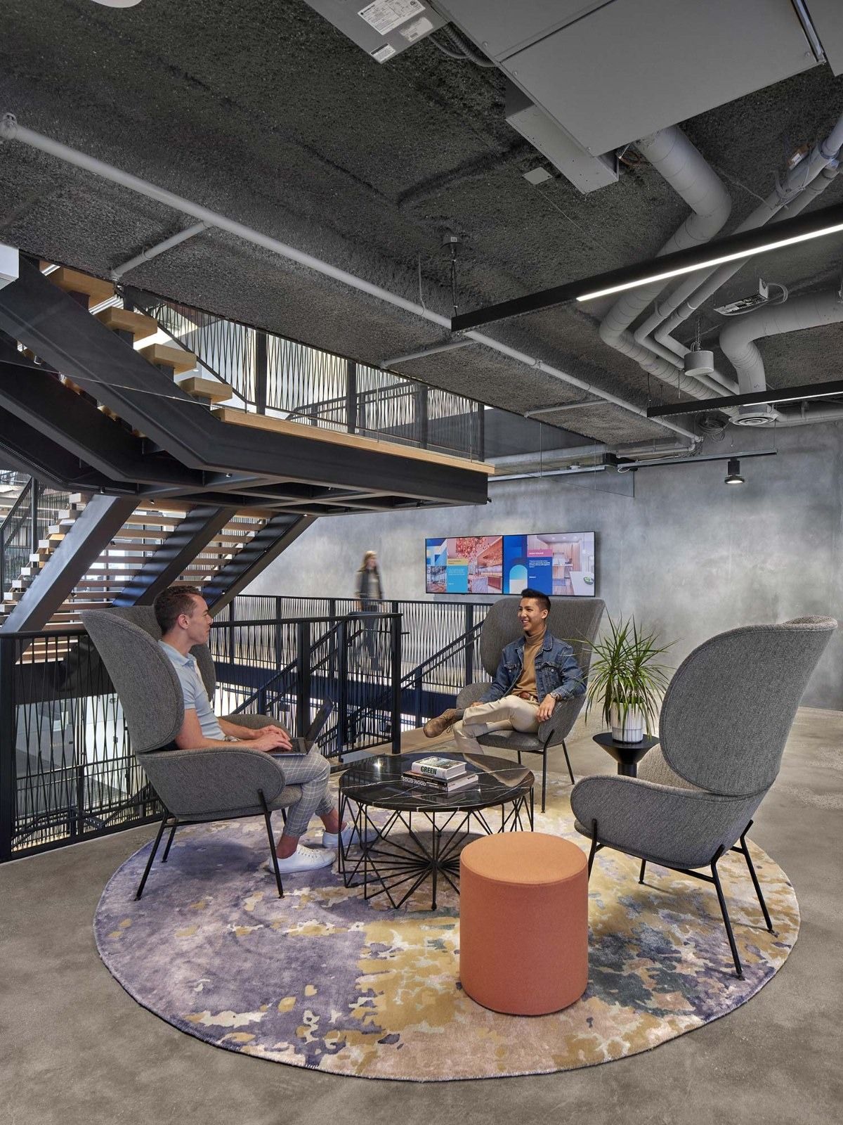 AvalonBay Communities: Lounge chairs on a round rug beside a black stair