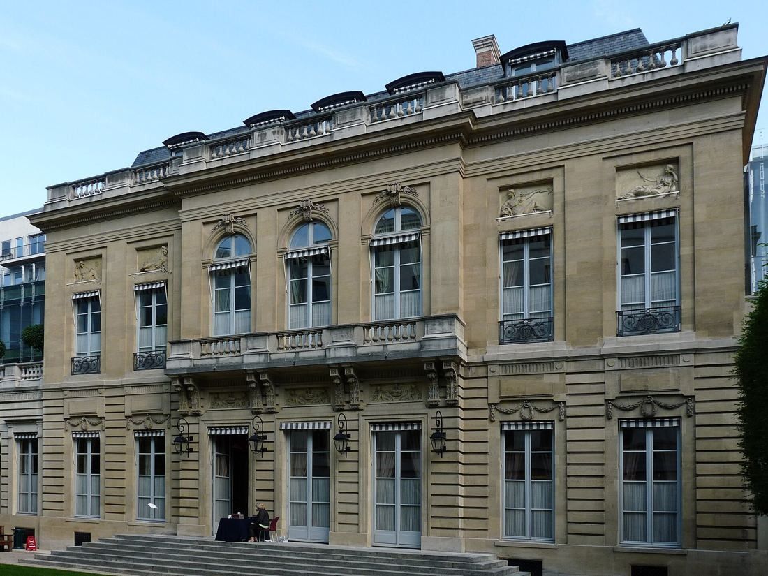 AXA: Classical stone mansion façade with tall windows and a balustrade
