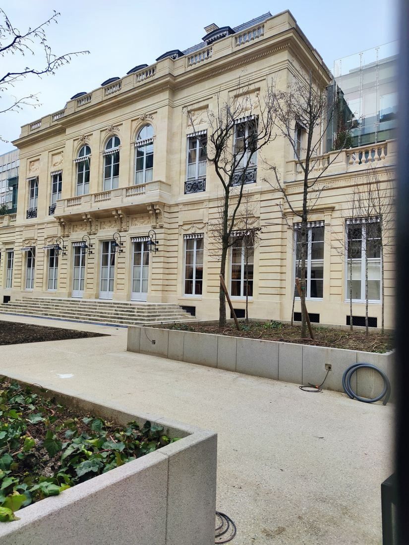 AXA: Cream stone mansion behind a planted forecourt