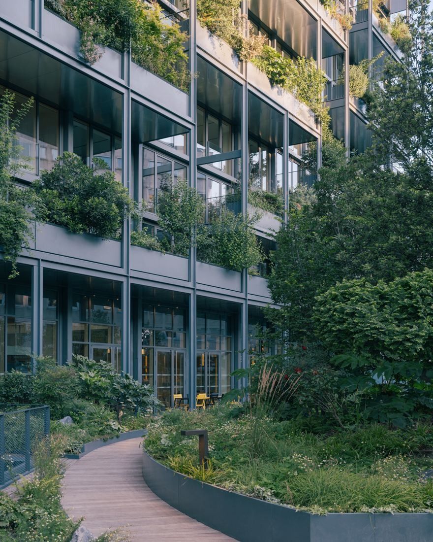 AXA: Curving garden path beside a façade with planted balconies