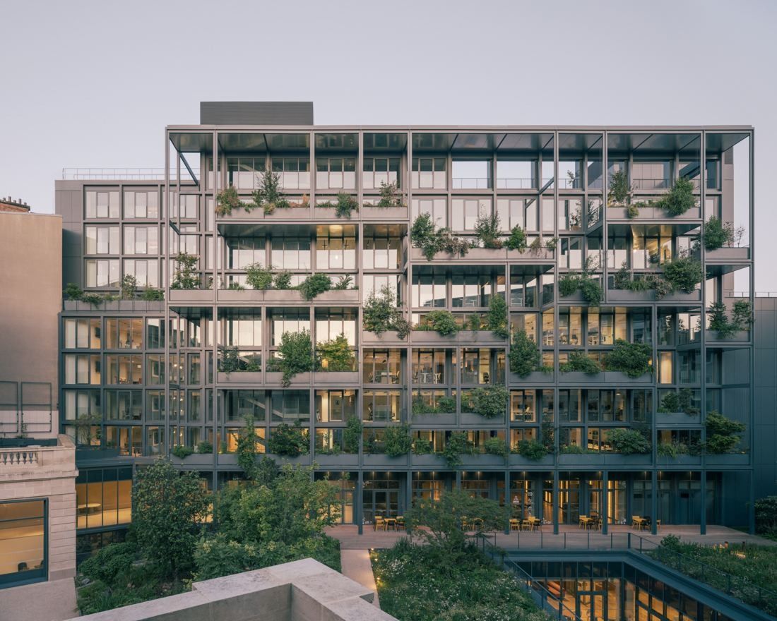 AXA: Daytime view of a glass building with greenery spilling over each floor