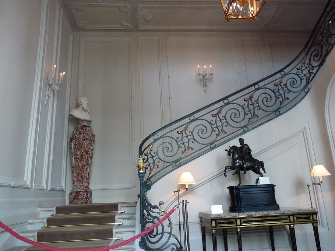 AXA: Entrance hall with a curving wrought-iron staircase and a lantern