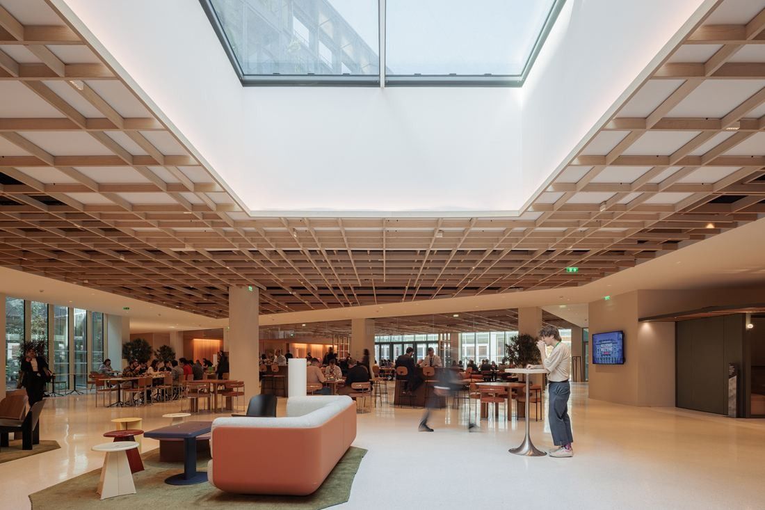 AXA: Large open hall with a wooden lattice ceiling, a skylight and café tables