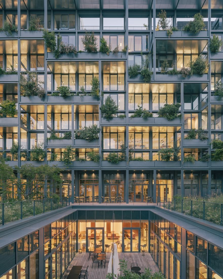AXA: Lit office floors with plants on every level above a glazed ground floor