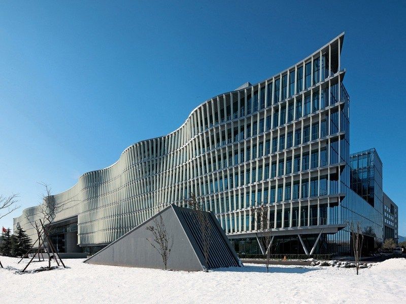 Curving building with rows of angled glass louvres, snow on the ground