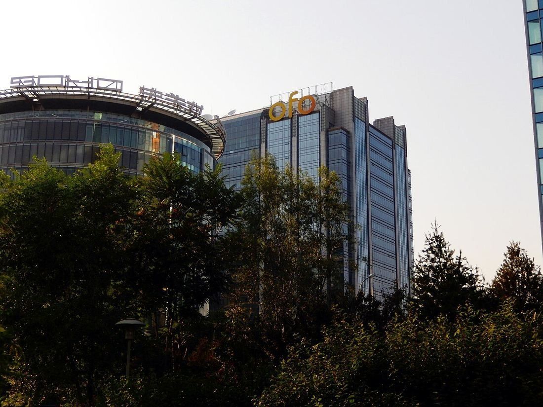 Glass office tower of Ideal International Plaza behind trees