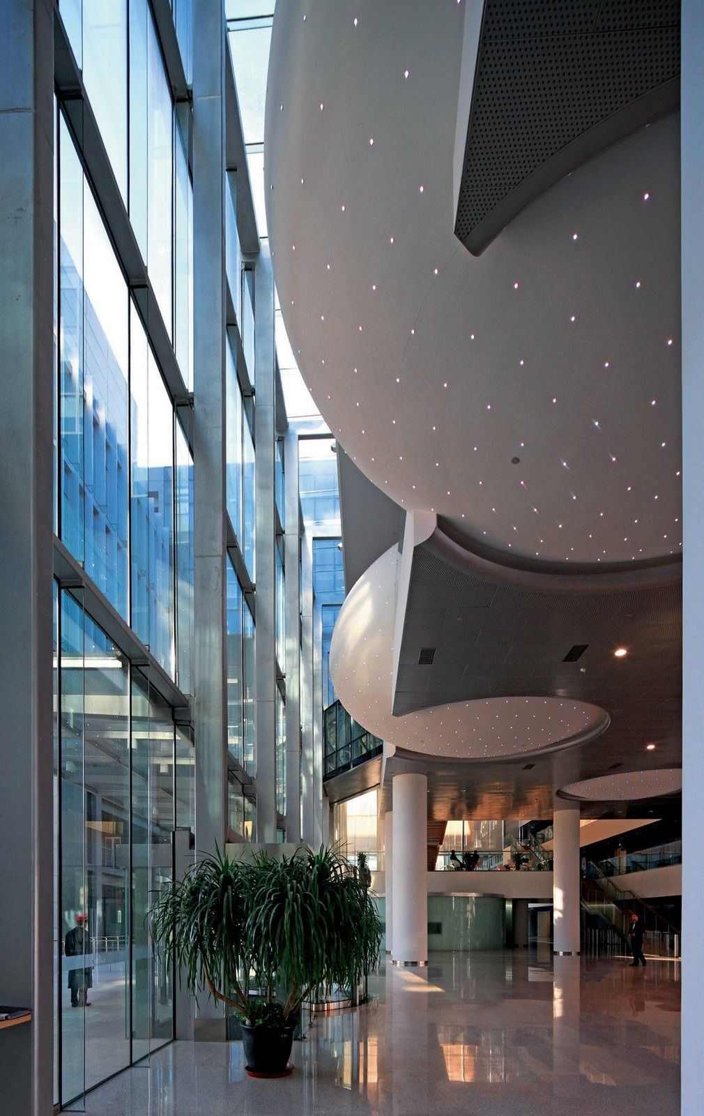 Baidu: Tall interior with a curved white ceiling and plants by a glass wall