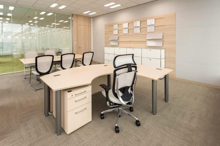 Bandai Namco: Private office with a curved pale-wood desk, a mesh chair and a small meeting table