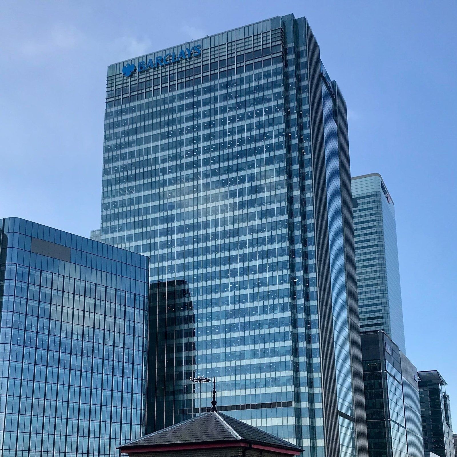 Barclays: Glass tower with a logo at the top against a clear sky