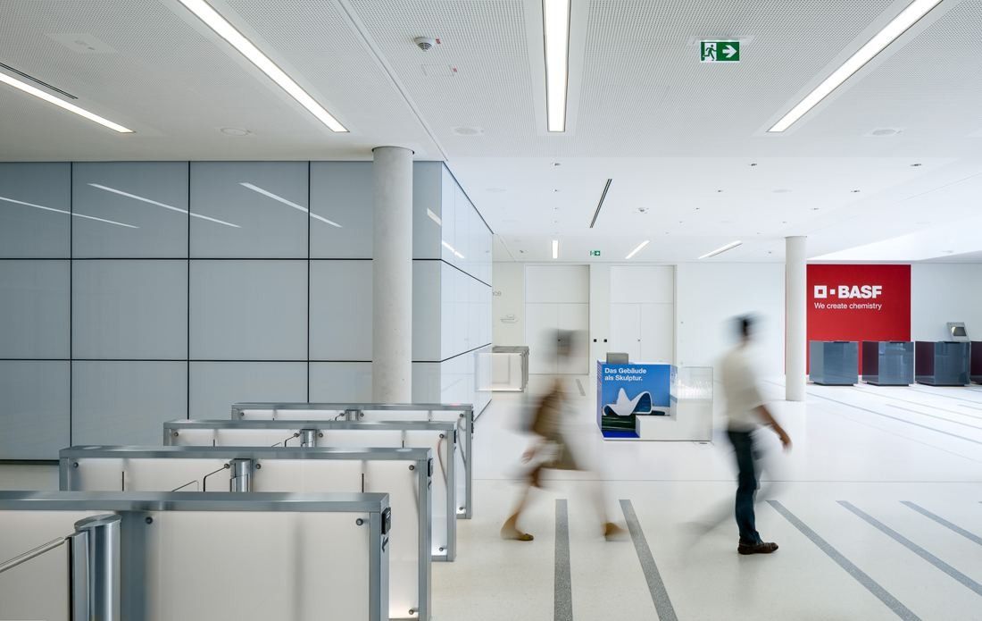 Entrance gates in a white hall with people blurred in motion