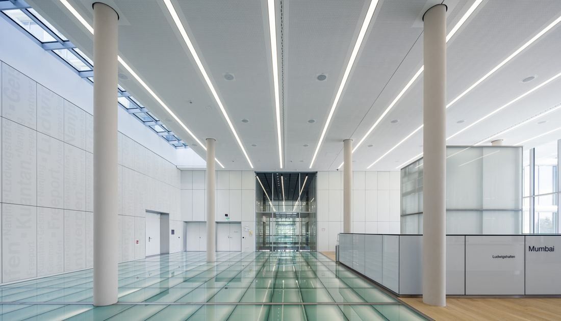 Long white hall with columns and linear ceiling lights