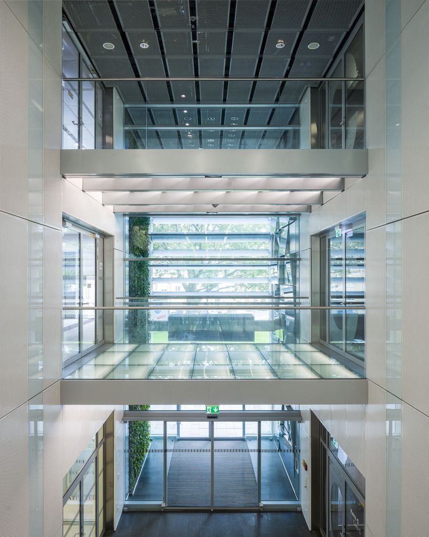 View up a tall white atrium crossed by glass bridges