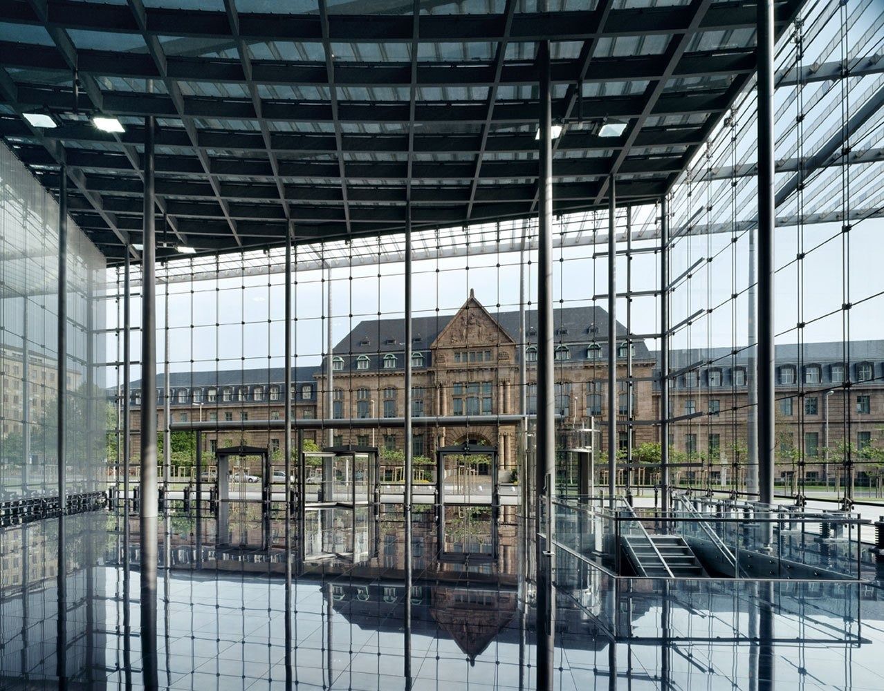 Bayer: Glass entrance hall looking out to a red-brick building
