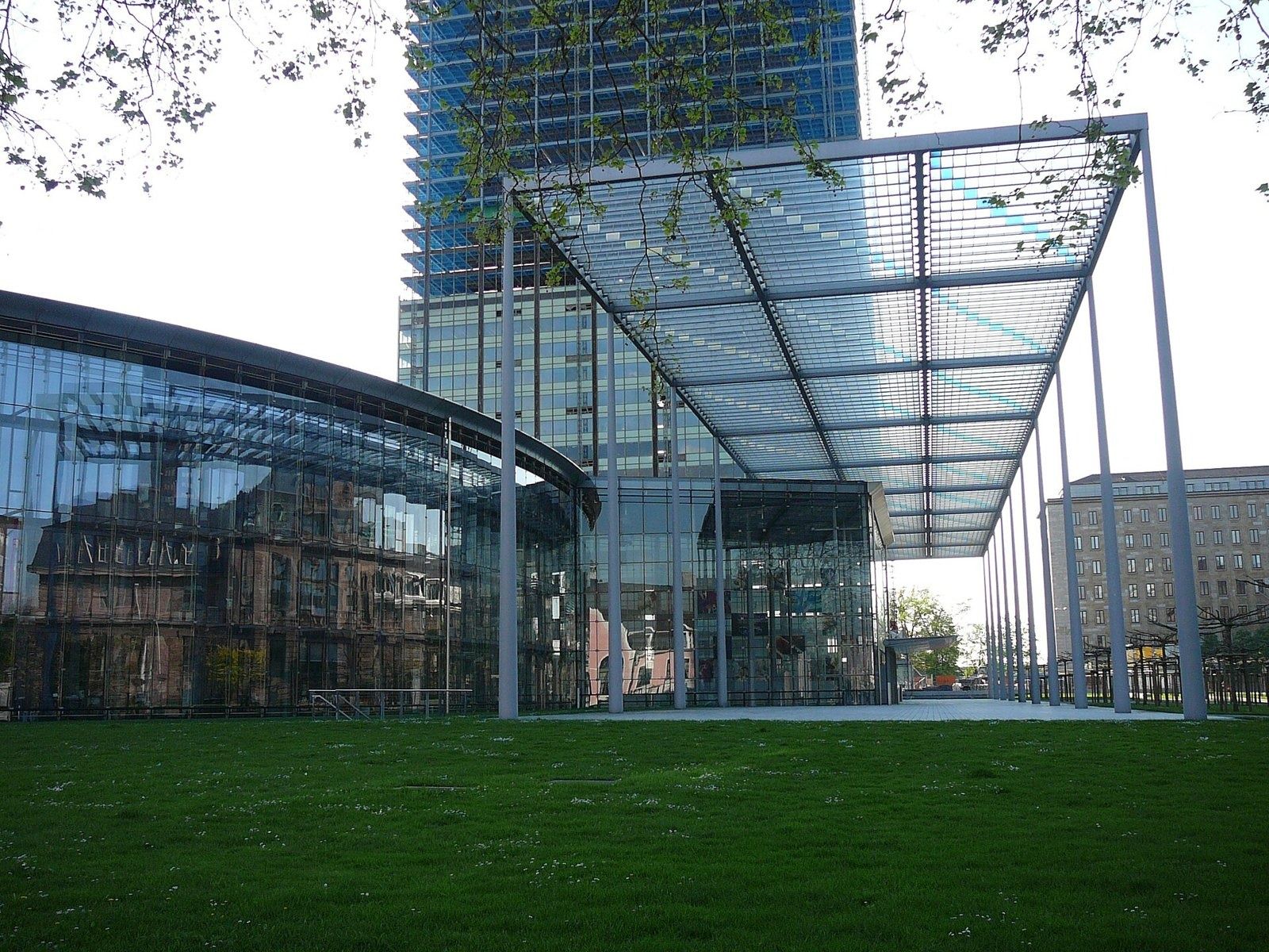 Bayer: Glass pavilion and a tower behind a lawn