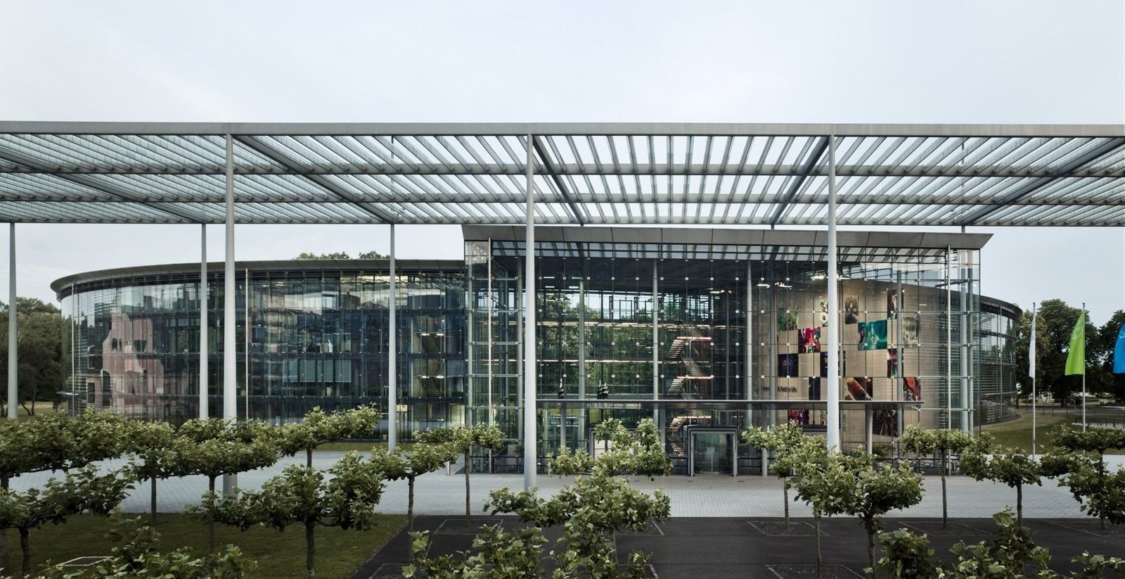 Bayer: Glass pavilion and pergola beside a lawn