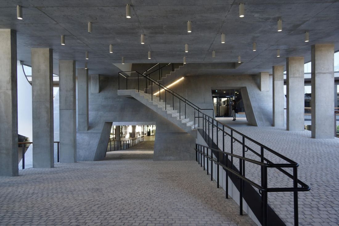BBVA: Concrete ramp with black railings under a columned canopy