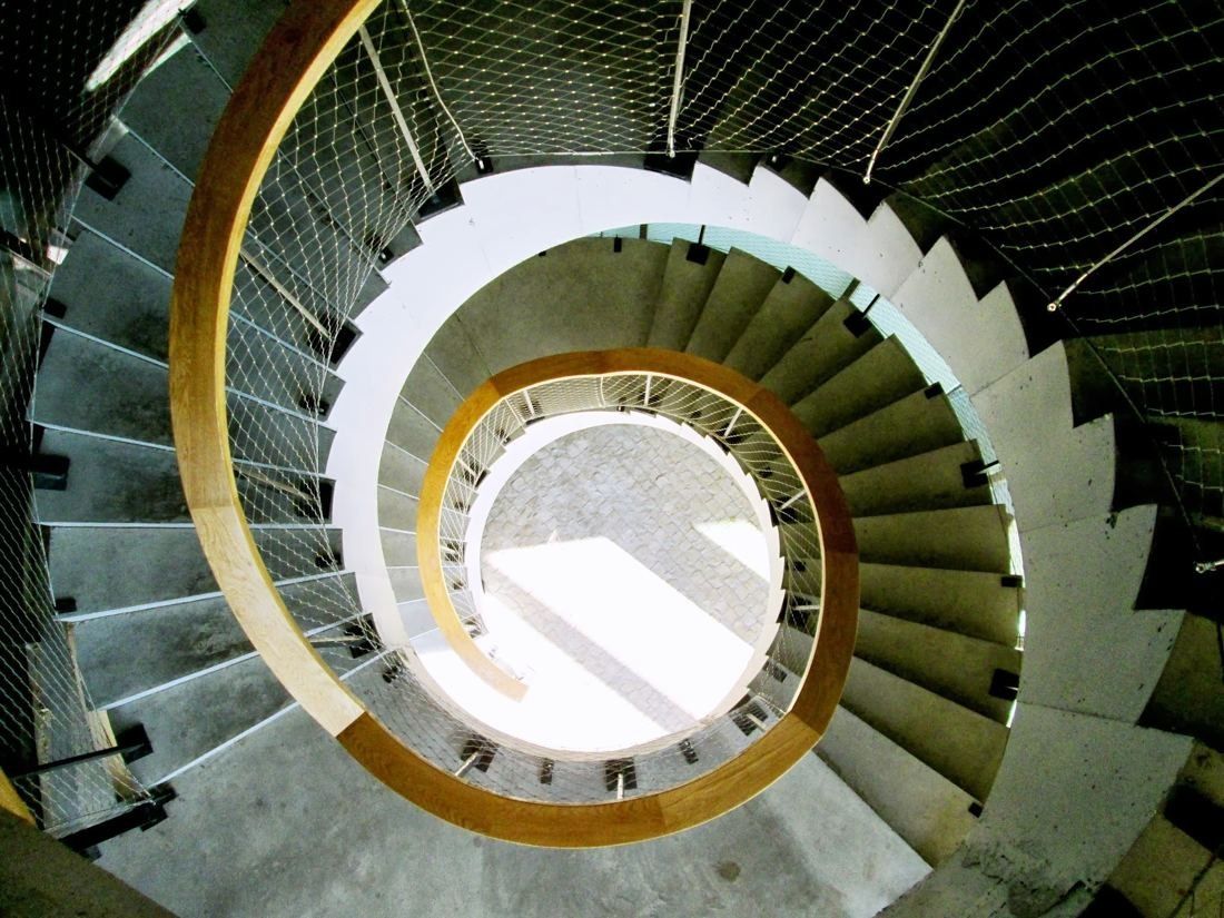 BBVA: Looking down a concrete spiral staircase with a golden handrail