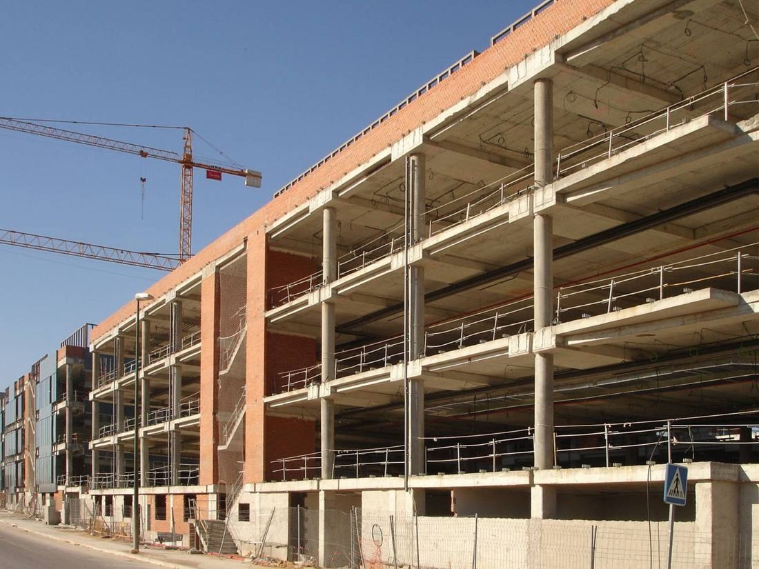 BBVA: Unfinished concrete office frame with brick walls and a crane