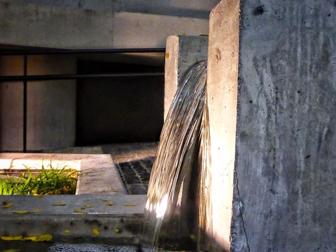 BBVA: Water falling into a narrow channel beside a rough concrete wall