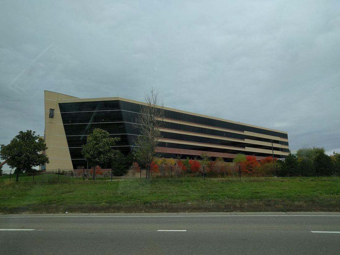 Best Buy: Long low office building with a sloping glass end behind a grassy verge