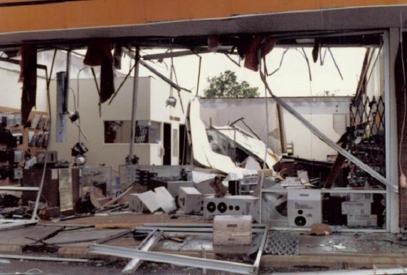 Store interior with collapsed ceiling, broken walls and scattered audio equipment after a storm