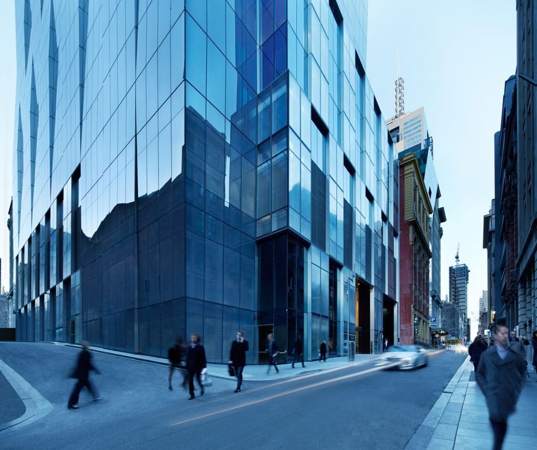 BHP: Glass tower at a street corner with pedestrians walking past