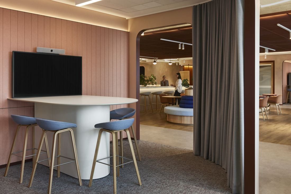 BHP: Pink-panelled meeting nook with a high table and stools, a curtain opening onto the floor beyond