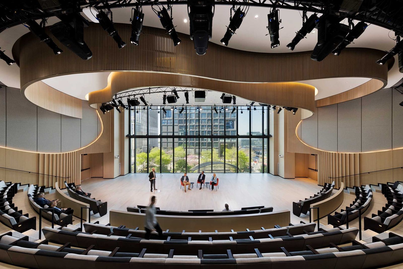 Curved auditorium with tiered seats facing a glass wall