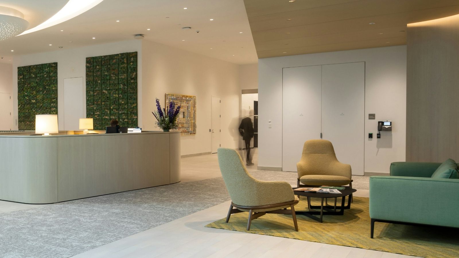 BlackRock: Lounge with green upholstered chairs and a plant wall
