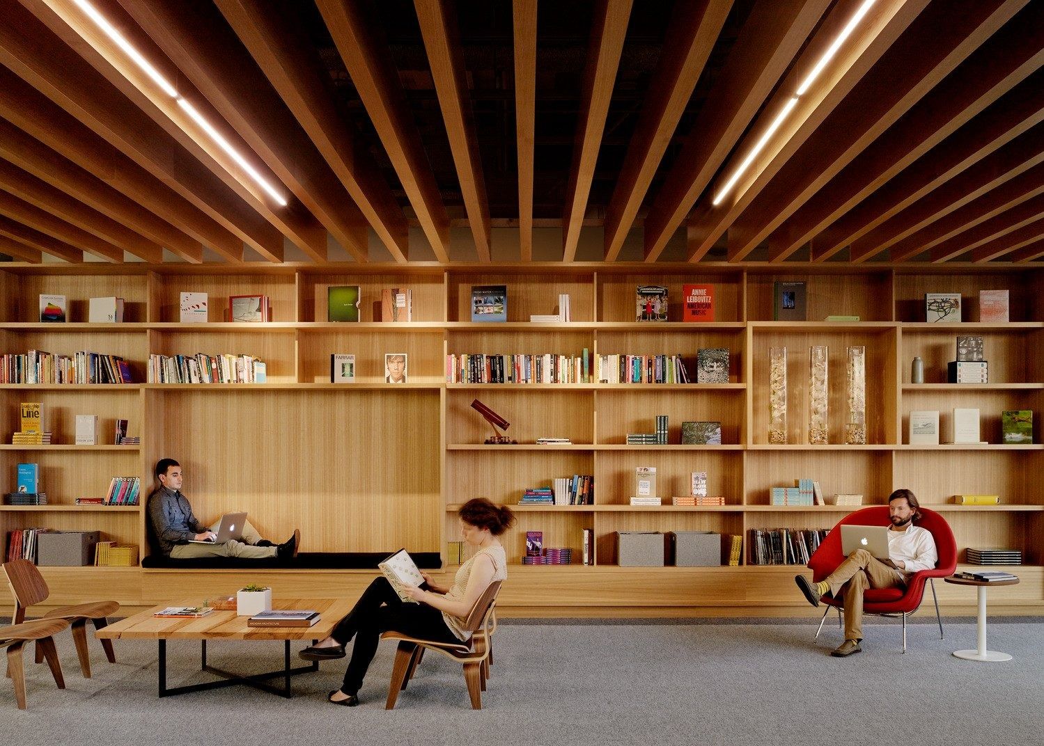 Block: A library wall of timber shelves under exposed beams