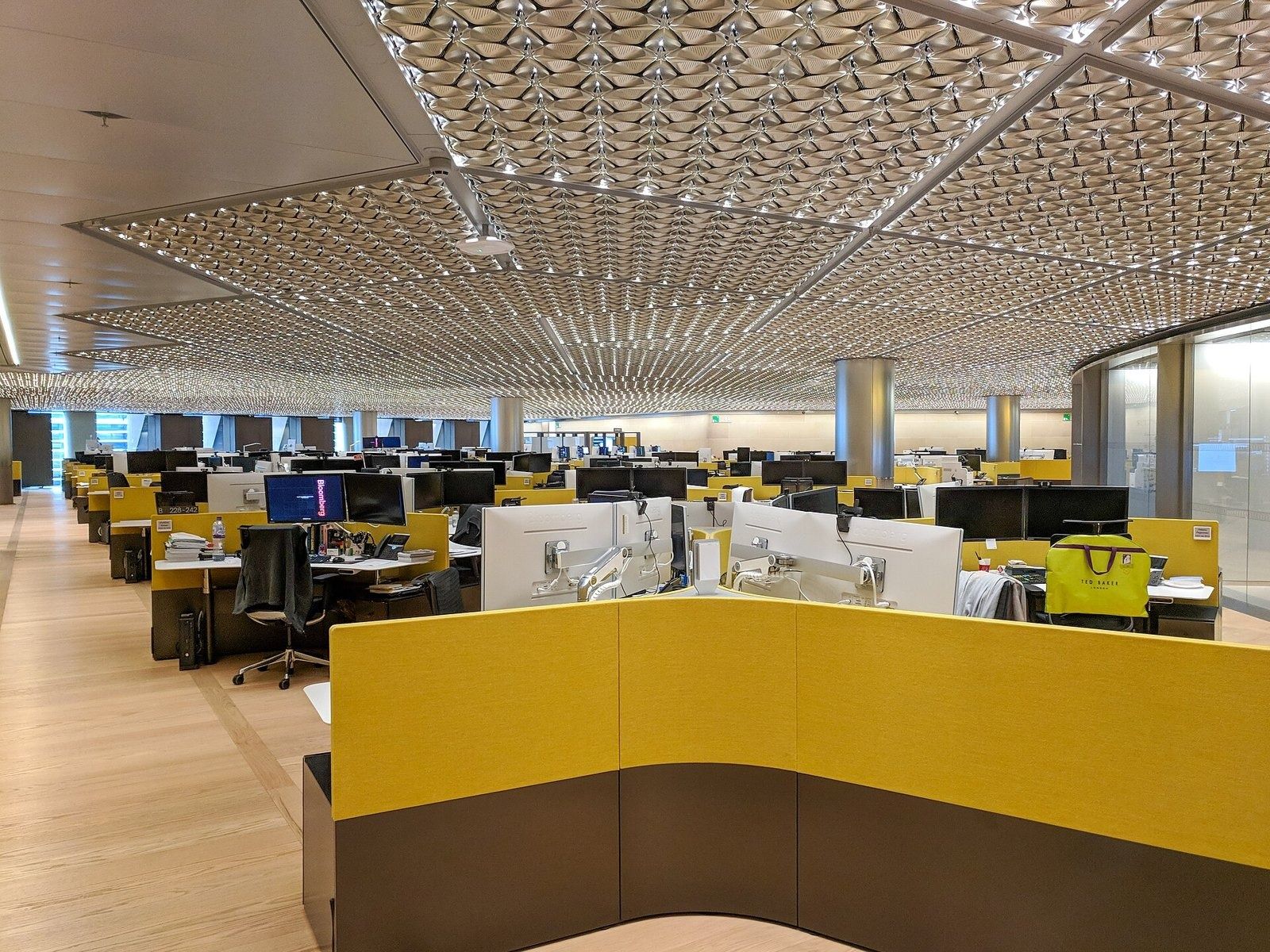 Bloomberg: An open trading floor with yellow desks under a metal ceiling