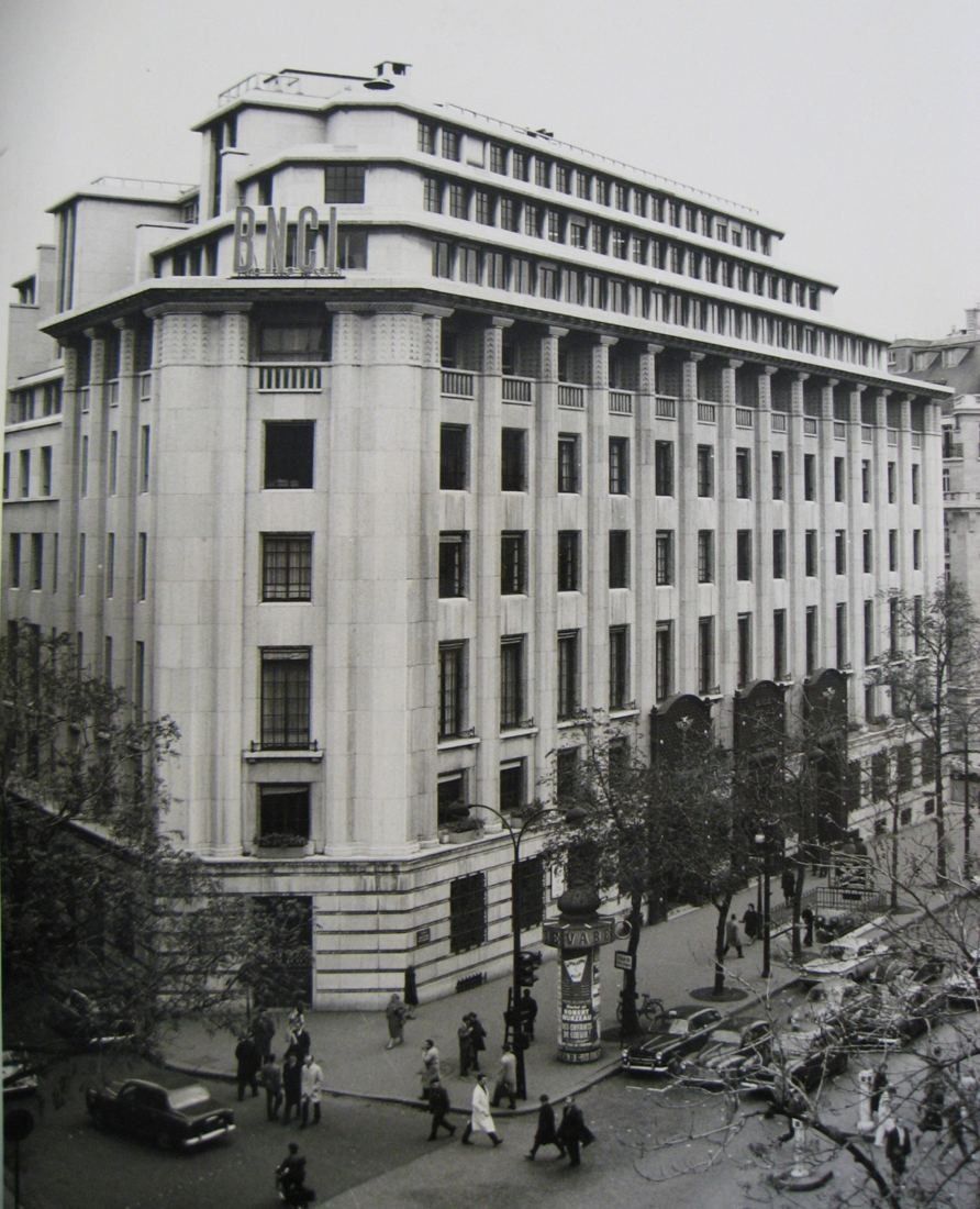 Black-and-white photo of the stepped stone building with BNCI letters on the roofline