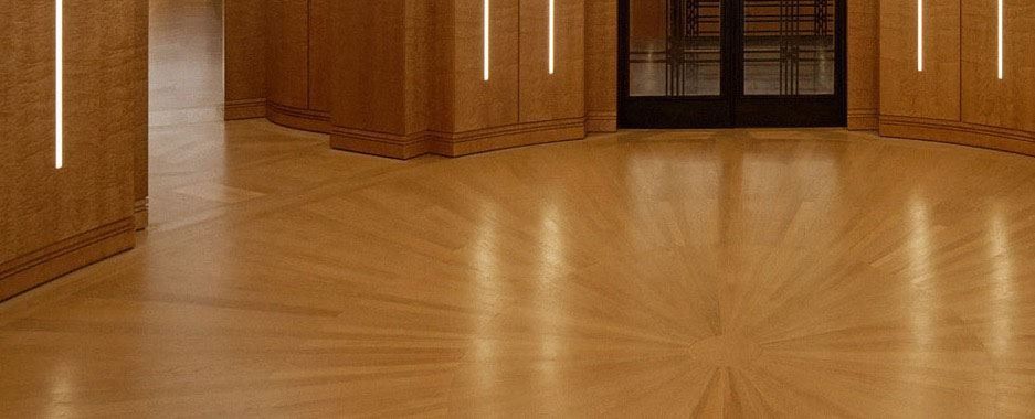 BNP Paribas: Curved wood-panelled room with a radiating parquet floor and a dark metal door