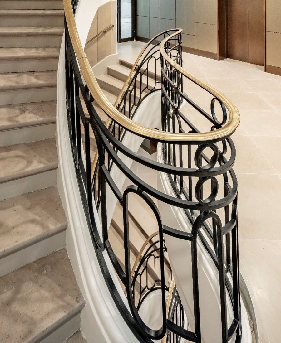 BNP Paribas: Curving staircase with a wrought-iron balustrade and brass handrail